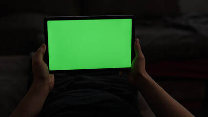 Naklejka premium POV view of tablet pc with green screen in man hands