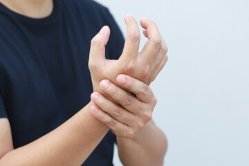  Closeup of male arms holding his painful wrist caused by prolonged work office syndrome....