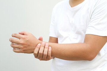 Closeup of male arms holding his painful wrist caused by prolonged work office syndrome. rheumatoid...