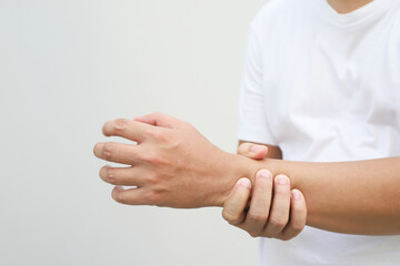 Closeup of male arms holding his painful wrist caused by prolonged work office syndrome. rheumatoid...