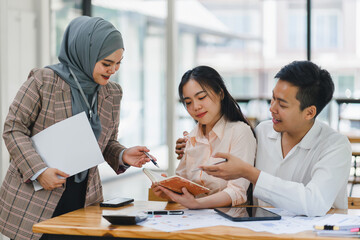 insurance agent pointing at clipboard in clients hand at tabletop in office, house insurance concept