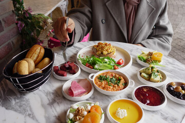  woman is enjoying turkish breakfast at cafe 