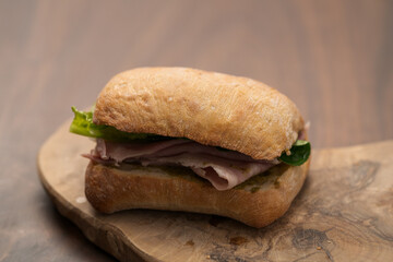 Ciabatta sandwich with ham and pesto closeup
