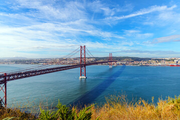 panoramic photo of the cityscape of Lisbon and the 25 April red bridge over the Tagus river on a sunny autumn day