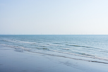 Seaside with the wind turbine over the ocean