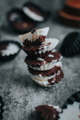 Stack of vegan chocolate cups with caramel on white tabletop. Homemade vegetarian chocolate caramel cups. Ideas and recipes for healthy sweets and dessert. Selective focus. Copy space for text.