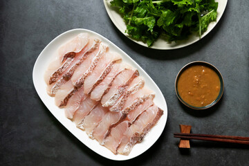 Delicious and healthy meal for hot pot of grouper fish slice and vegetables with a spicy soy bean dipping sauce.