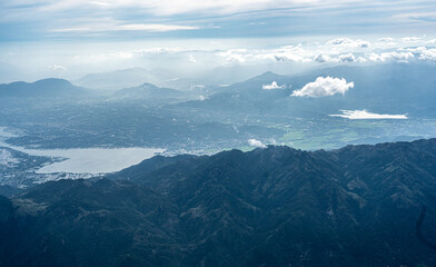 Aerial Serenity: Blue-Toned Landscape Journey Revealing Majestic Mountains, Water Bodies, Villages, and Small Towns