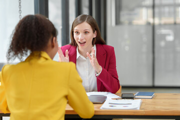 Fototapeta premium Confident African American team leader teaching employees Advice for business women Colleagues share ideas Plan work on financial projects online Discuss strategies together.