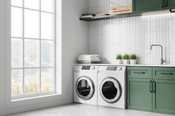 White and green home laundry interior with washing machines and sink, window