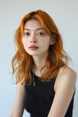 オレンジの髪色のファッショナブルな日本人女性（ヘアモデル・ヘアカタログ・美容室）