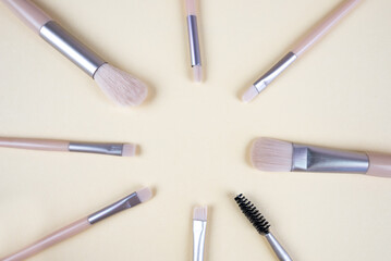 Set of brushes for cosmetics isolated on a beige background.