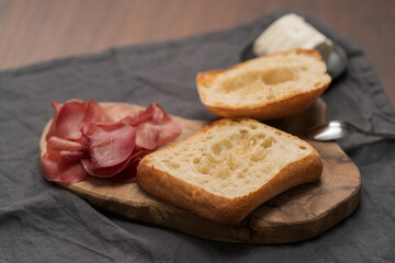 Ingredients for sandwich with bresaola, pesto and balsamic on olive board