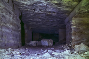 In the underground quarry, the walls and the arched arch of the entrance are lined with stones....