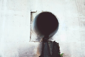 Dirty water flows out of the old rusty pipe without cleaning. Pollution of natural water bodies....