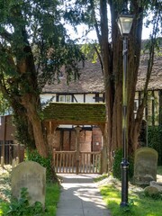 headstones with the lychgates of Chalfont St Giles Church in the background Buckinghamshire England