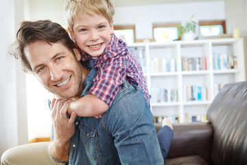 Portrait, father and son on sofa with piggyback, bonding and love in living room for playful family in home. Relax, dad and child on couch for happy weekend together with fun, smile and embrace.