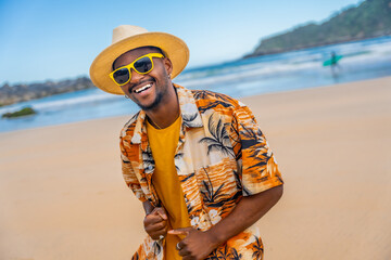 Afro american man in summer clothes dancing happily at beach
