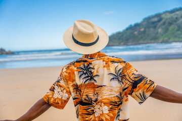African american man opening arms gazing the beach