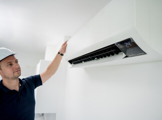 technician cleans air conditioner system in a modern apartment.