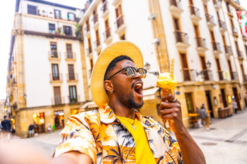 Brunette man taking selfie while biting an ice cream