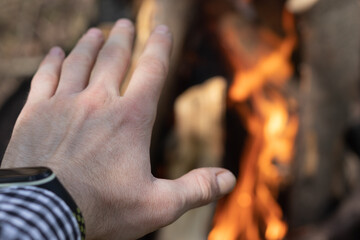 A man warming his hand by fire