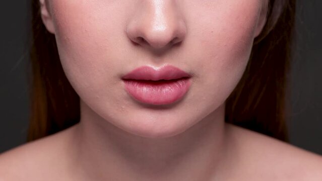 Young attractive woman with beautiful make-up and plump lips. She bites her lips