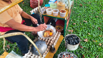 Man Selling Kerak Telor Traditional Street Food From Jakarta, Kerak Telor or sticky rice omelet is...