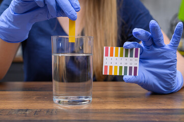 Wkładać papier lakmusowy do szklanki z wodą z kranu, sprawdzać pH wody