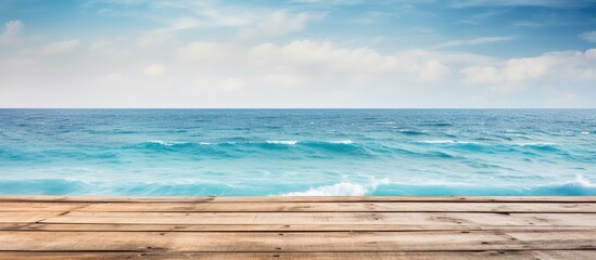 A rustic wooden pier extending over the serene ocean featuring a stunning backdrop perfect for a copy space image