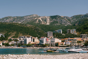 Boats are moored off the coast of the resort town against the backdrop of mountains