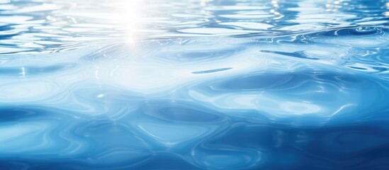 Obraz premium Closeup abstract blur of blue water surface with sunlight reflection ideal for graphic design with copy space image