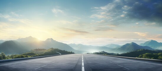 Panoramic view of a mountainous landscape with an asphalt highway leading through it at sunrise creating a picturesque copy space image