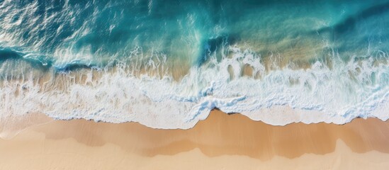 Bird s eye perspective showcasing a tranquil blue ocean meeting sandy shores with a vast expanse of golden beach in the background ideal for a copy space image