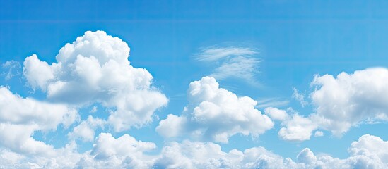 Panoramic view of a clear blue sky with white fluffy clouds ideal for copy space image