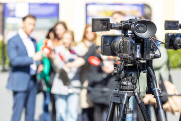 Filming press conference, media or publicity event with television camera, unrecognizable...