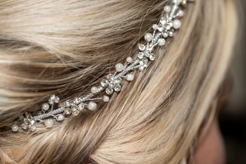 détail d'une coiffure de mariée avec des strass et des perles sur cheveux blonds