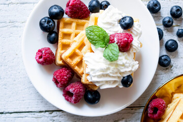 
Belgian Waffles with cream and fruit. on a wooden background. dessert