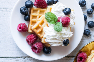 
Belgian Waffles with cream and fruit. on a wooden background. dessert