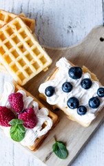 
Belgian Waffles with cream and fruit. on a wooden background. dessert