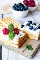 
Belgian Waffles with cream and fruit. on a wooden background. dessert