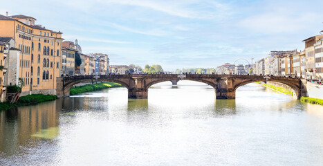 Obraz premium Florence, Italy - April 10, 2024: View of the Santa Trinita Bridge in Florence with tourists crowding its surroundings in Florence, Italy