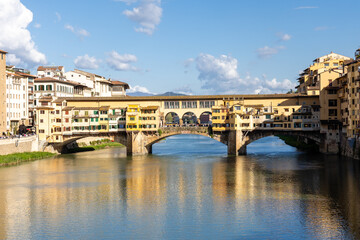 Obraz premium Florence, Italy - April 10, 2024: View of the Vecchio Bridge in Florence with tourists crowding its surroundings in Florence, Italy
