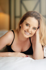 Fototapeta premium Hotel, bed and portrait of woman to relax in morning or wake up in home on holiday or vacation. Calm, person and face of girl in bedroom at villa to rest at accommodation or lodge with happiness