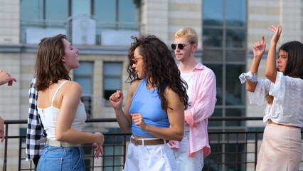 Happy young people dancing having fun at rooftop party in good mood. Positive emotion. Close-up....