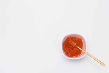 salmon red caviar in a saucer on a white background