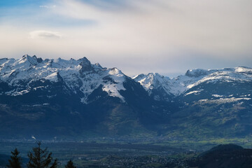 The mountains are covered in snow and the sky is cloudy