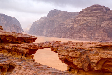 Jordanian Wadi Rum rocky Little Bridge with cloudy moody sky in background 