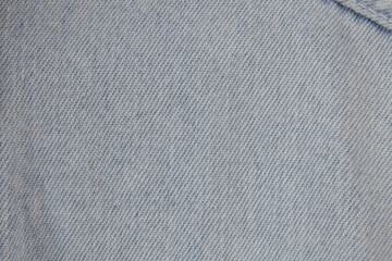 Light grey denim jeans texture. Straight surface, macro closeup overhead shot of the fibers.
