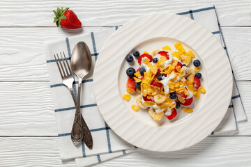 fresh berries, banana with corn flakes and yogurt
